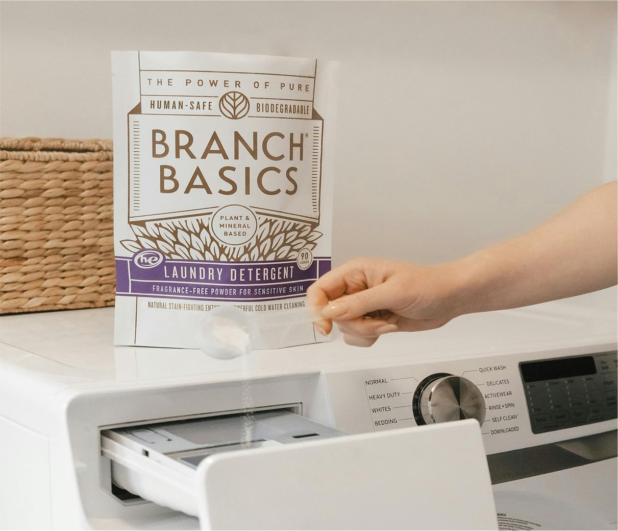 Person opening a washing machine with Branch Basics Laundry Detergent in the foreground. - View 7
