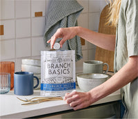 A standing bag of Dishwasher Tablets with a hand extracting a single Dishwasher Tablet from the bag. - Thumbnail View 8
