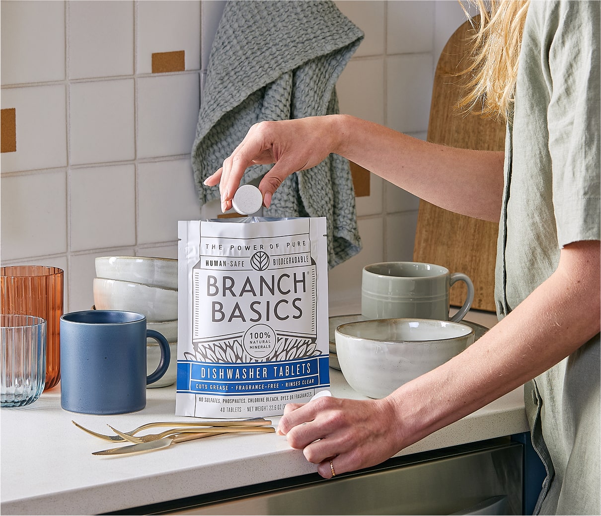 A standing bag of Dishwasher Tablets with a hand extracting a single Dishwasher Tablet from the bag. - View 8
