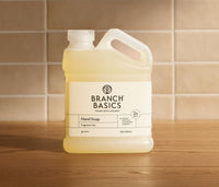 Branch Basics hand soap refill bottle on a wooden surface with a tiled wall background - Thumbnail View 1
