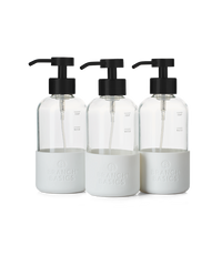 A trio of refillable Glass Foaming Wash Bottles with Matte-Black pumps, displayed on a transparent background. - Thumbnail View 1
