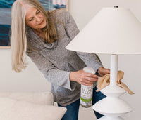 A person using the refillable Plastic All-Purpose bottle and a cloth to clean furniture in their home. - Thumbnail View 4
