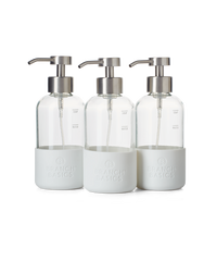 A trio of refillable Glass Foaming Wash Bottles with Brushed-Chrome pumps, displayed on a transparent background. - Thumbnail View 1
