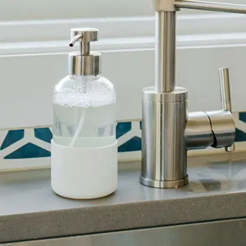 Glass Foaming Wash dispenser on a kitchen counter with a tiled backsplash