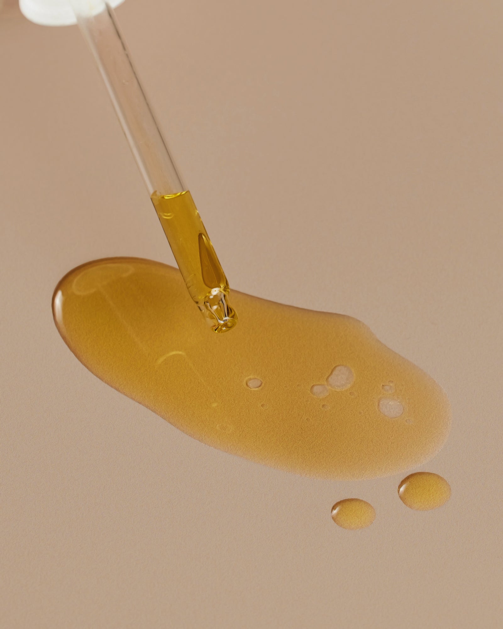 A dropper of Meadowfoam Oil and a pool of Meadowfoam Oil positioned against a neutral background. - Card 3