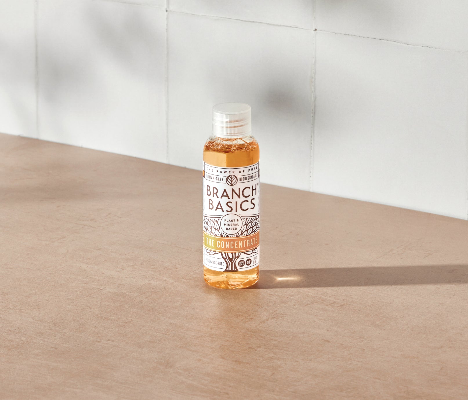 A mini-bottle of the Branch Basics Concentrate, displayed on a neutral surface and white tiled background. - View 2
