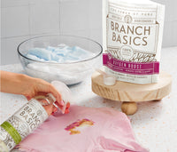 A person using Branch Basics Concentrate and Oxygen Boost to clean a stain, with a pouch of Oxygen Boost in the foreground. - Thumbnail View 4
