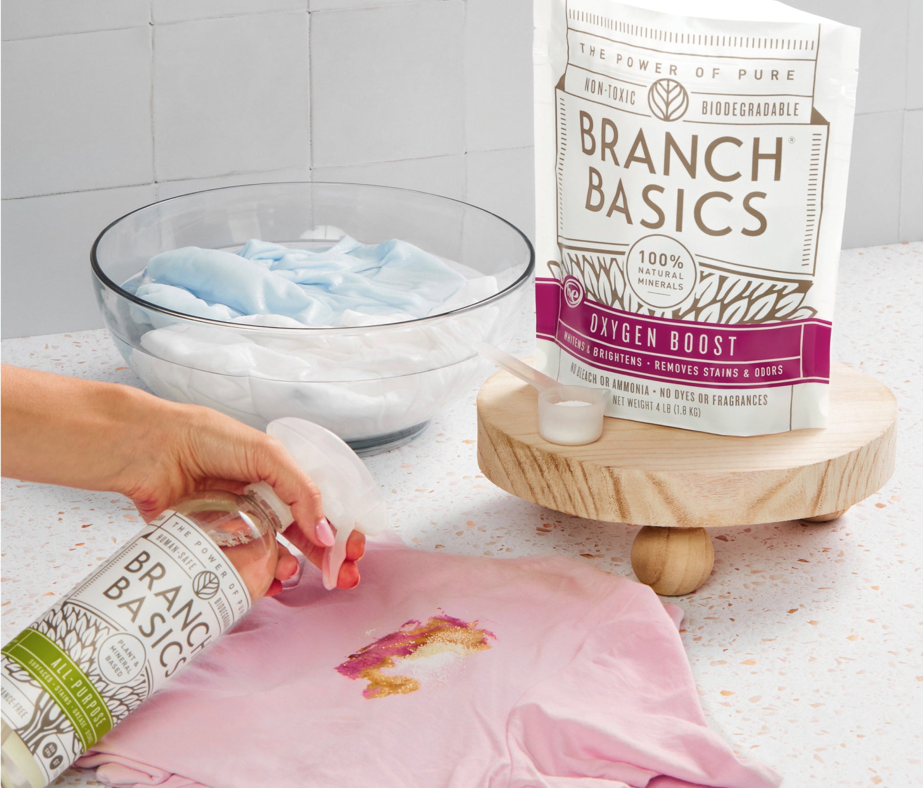 A person using Branch Basics Concentrate and Oxygen Boost to clean a stain, with a pouch of Oxygen Boost in the foreground. - View 4
