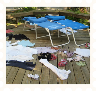 Blue folding chairs on a wooden deck with clothes scattered around; image contained within a frame to look like a stamp.