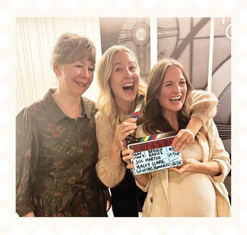 Marilee, Allison, and Kelly laughing together while holding a clapperboard; image contained within a frame to look like a stamp.